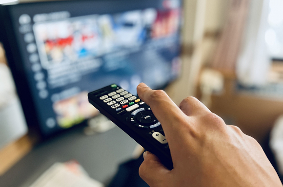 テレビのリモコンを持つ手